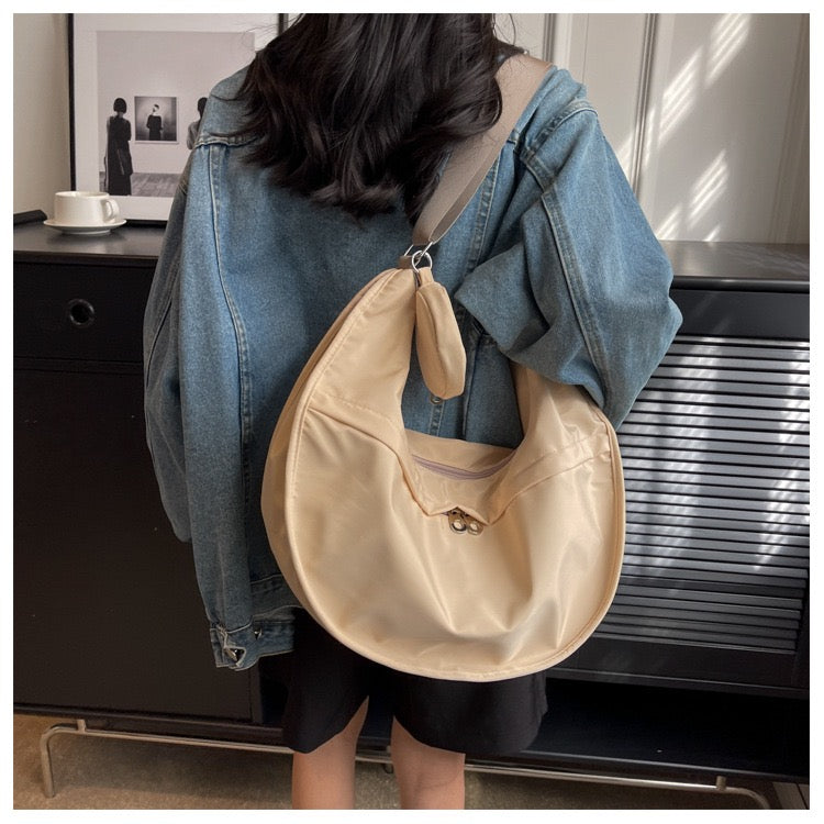 Woman wearing STOKADO khaki crescent crossbody bag